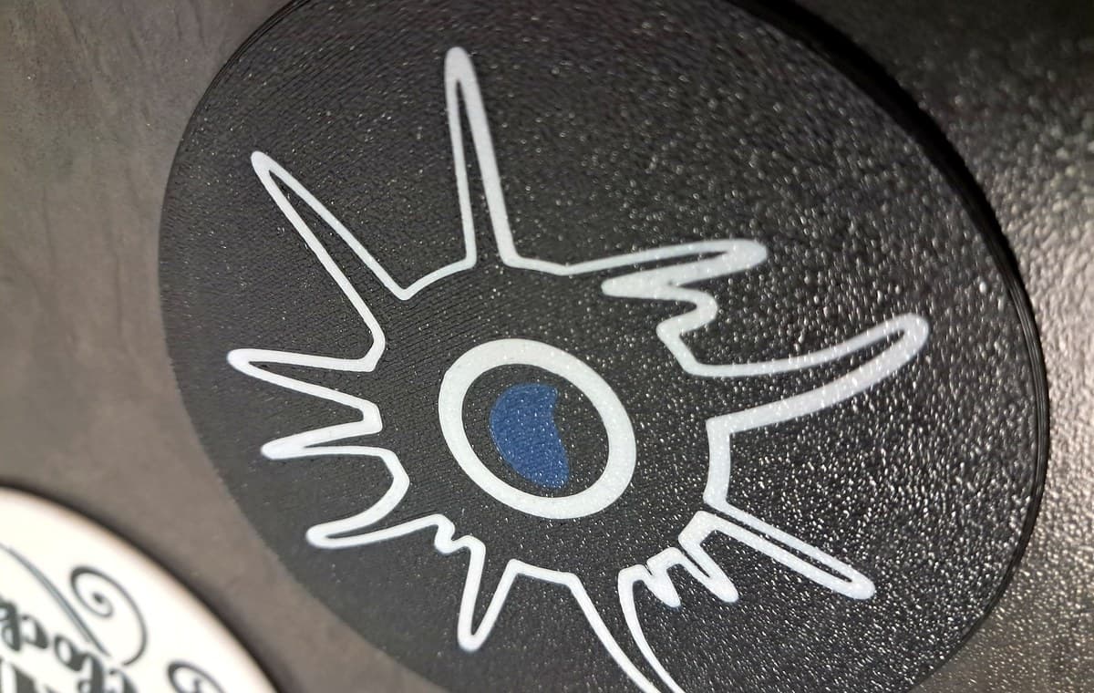 Actual multi-colour 3D printed coaster with clean flush black, white, and blue surface detail